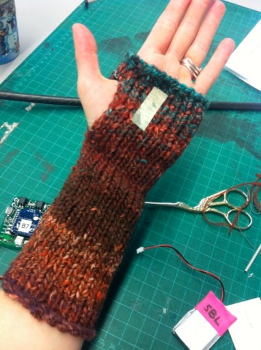 The wrist warmer with electronic circuitry to send a subtle 'nudge' to a partner wearing another circuit in their clothes.