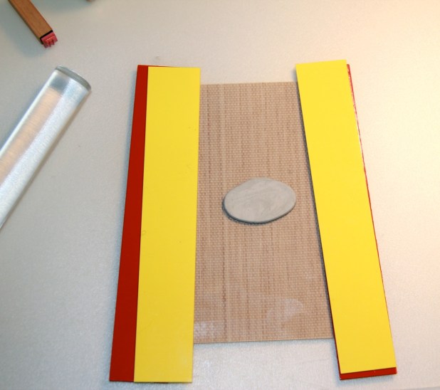 Here's the ball of clay rolled out flat. The plastic slats at each side allow you to roll the clay out to a specific thickness.
